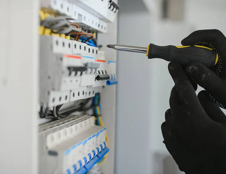 A local electrician carrying coiled wire and tools.