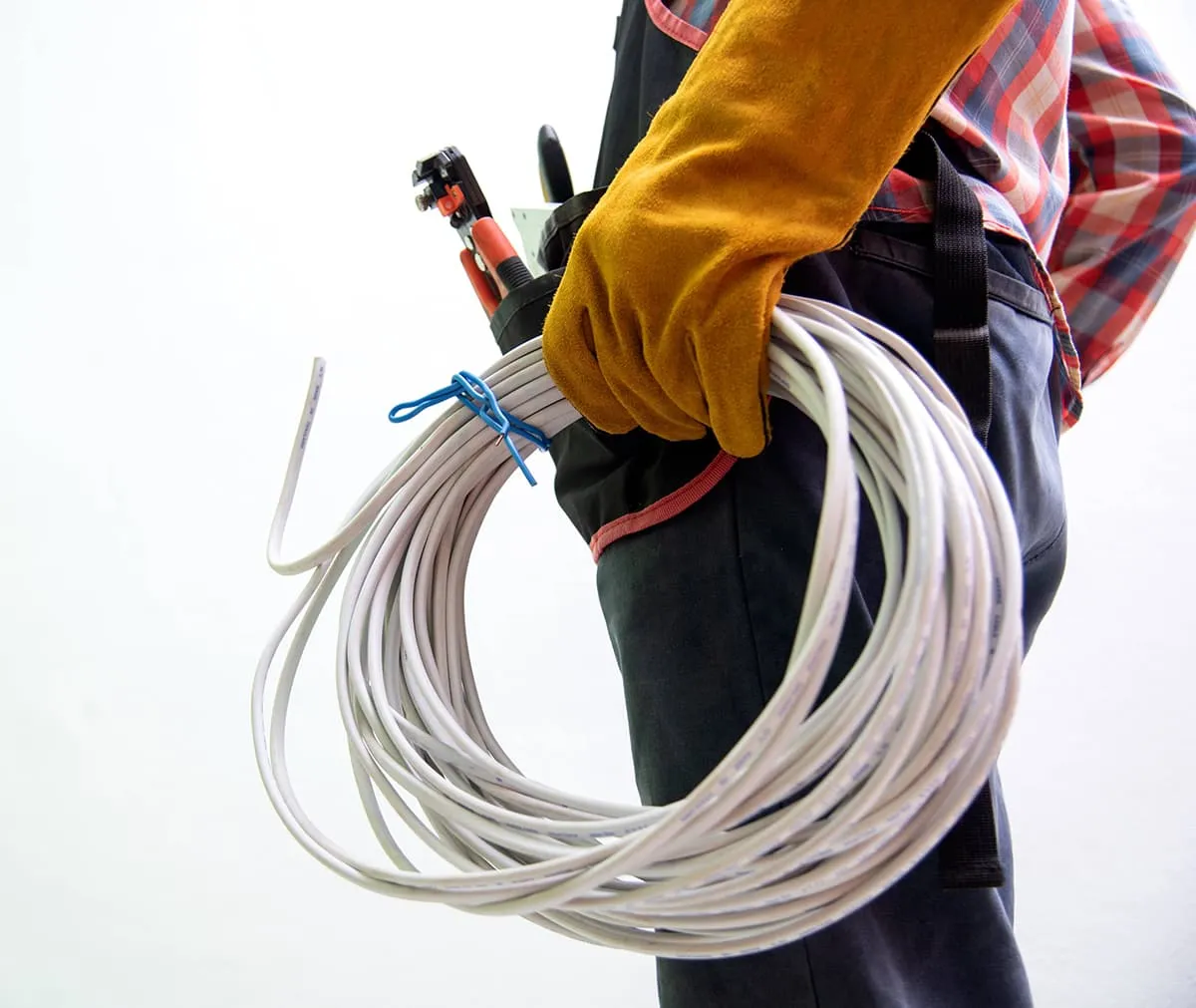Electrician carrying coiled wire and tools.