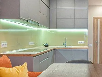 Under cabinet lighting illuminating a backsplash and countertop.